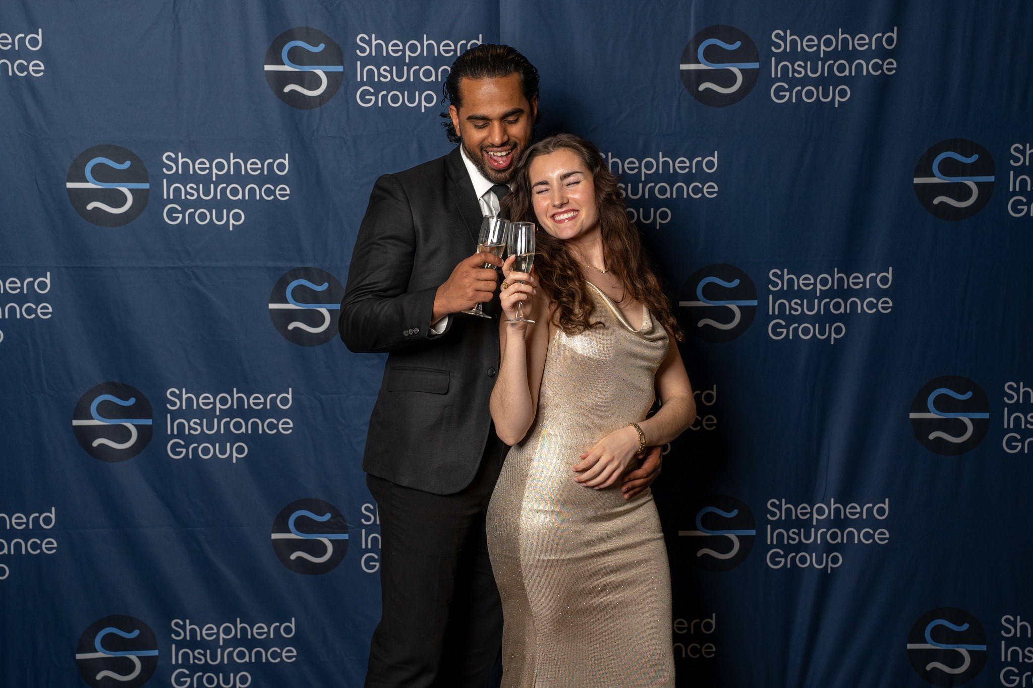 Gala guests celebrating in front of the Shepherd Insurance Group backdrop